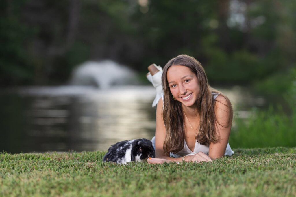 High school girl with rabbit in front of water fountain.